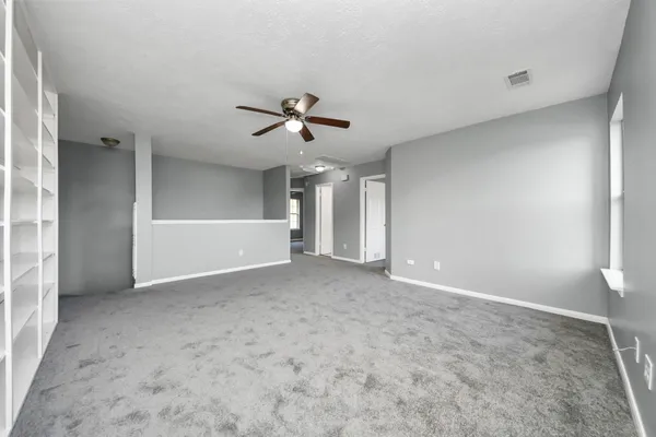 a view of a livingroom with a ceiling fan and window