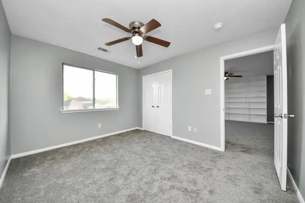 an empty room with closet and windows