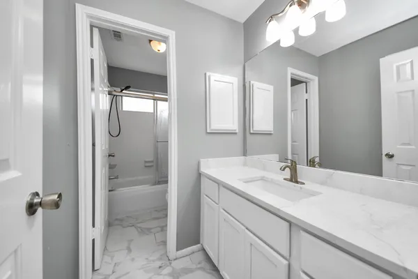 a bathroom with a sink vanity granite shower and a mirror