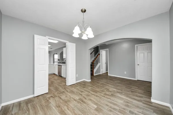 a view of a livingroom with a chandelier fan and windows