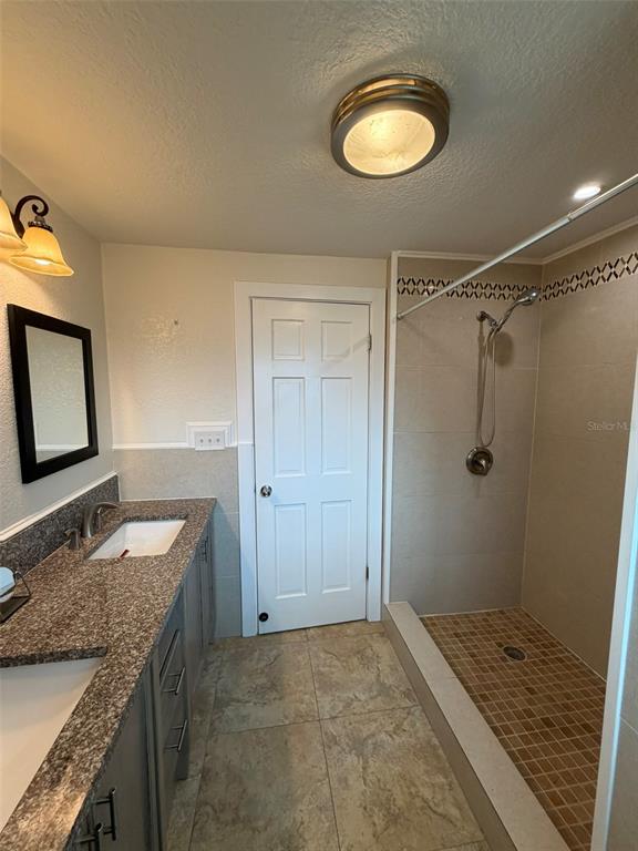 903 East New York Avenue Deland, FL 32724 - Photo 12 of 29 a bathroom with a granite countertop double vanity sink and mirror