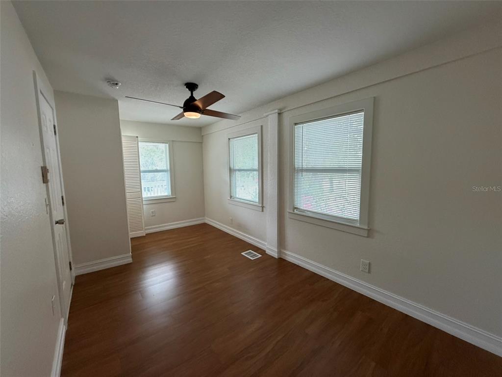 903 East New York Avenue Deland, FL 32724 - Photo 18 of 29 an empty room with wooden floor and windows