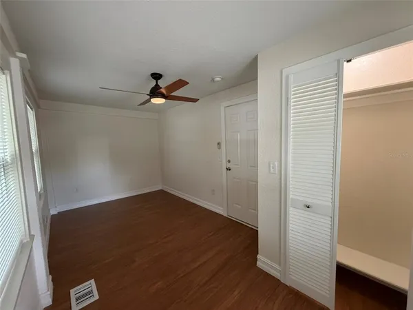 a view of a hallway with wooden floor and closet