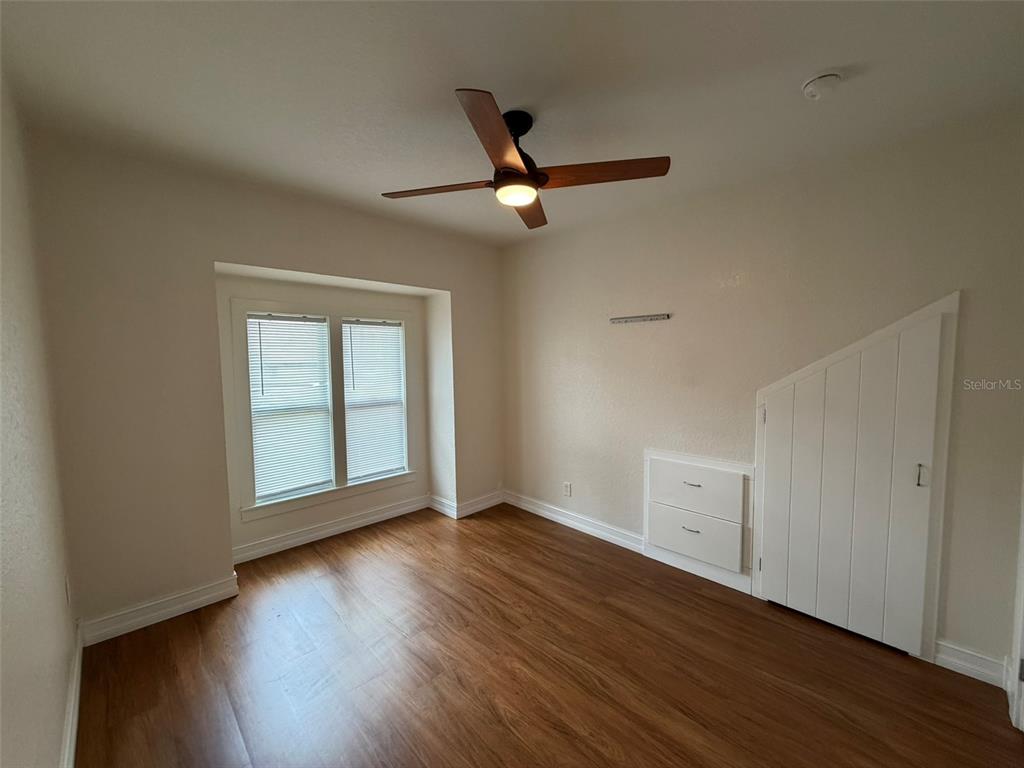 903 East New York Avenue Deland, FL 32724 - Photo 20 of 29 an empty room with wooden floor ceiling fan and windows