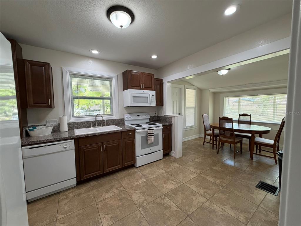 903 East New York Avenue Deland, FL 32724 - Photo 22 of 29 a kitchen with stainless steel appliances granite countertop sink stove top oven and cabinets