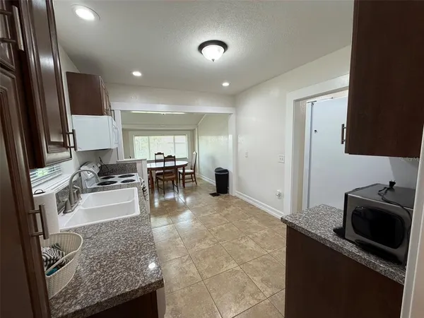 a kitchen with stainless steel appliances granite countertop sink stove refrigerator and cabinets