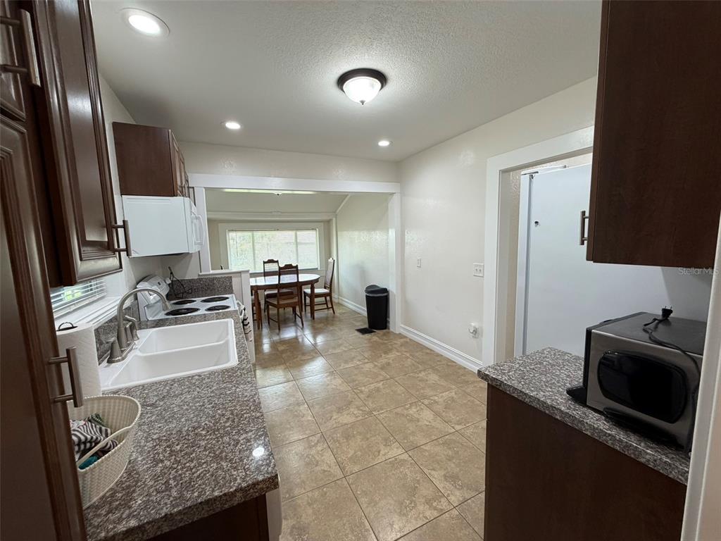 903 East New York Avenue Deland, FL 32724 - Photo 23 of 29 a kitchen with stainless steel appliances granite countertop sink stove refrigerator and cabinets