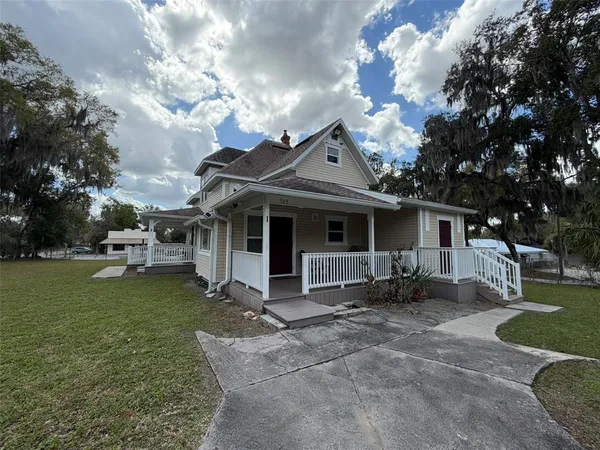 a view of a house with backyard porch and sitting area