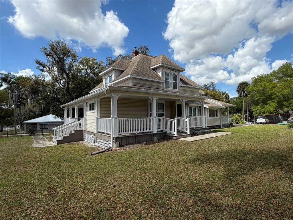 903 East New York Avenue Deland, FL 32724 - Photo 27 of 29 a view of a house with a big yard and large trees