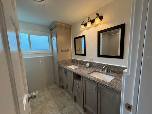 a bathroom with a double vanity sink and mirror