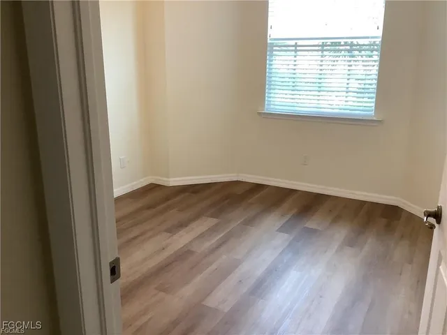 a view of a room that has wooden floor and windows