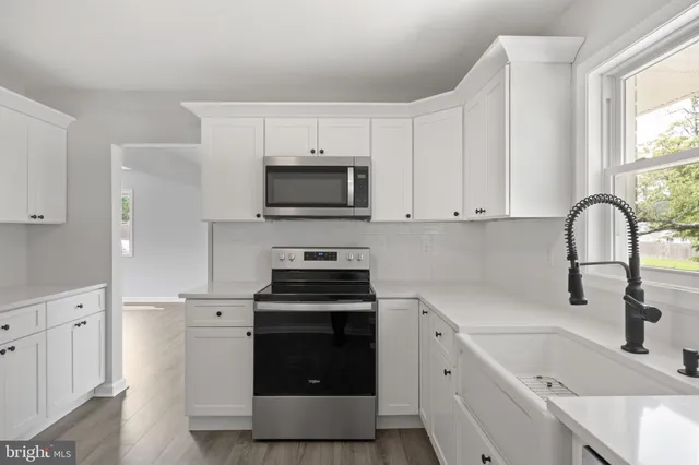 a kitchen with a sink stove and cabinets
