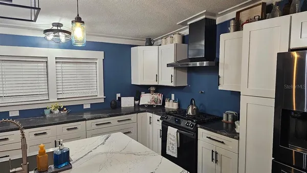 a kitchen with stainless steel appliances a sink stove and refrigerator