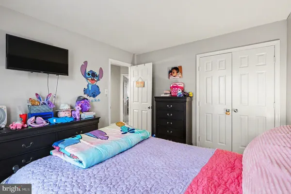 a bedroom with a bed a dresser and a flat screen tv