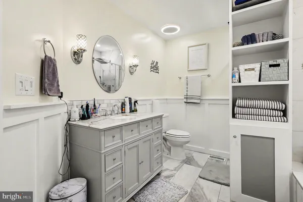 a bathroom with a toilet a sink and a mirror
