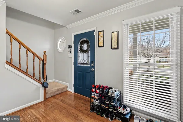 a view of a hallway with wooden floor and a dining room