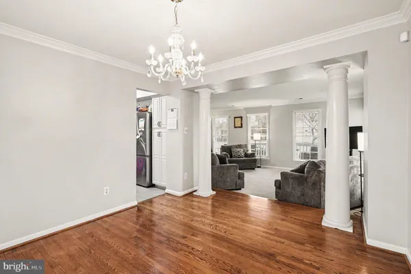 a view of a livingroom with a chandelier furniture and wooden floor