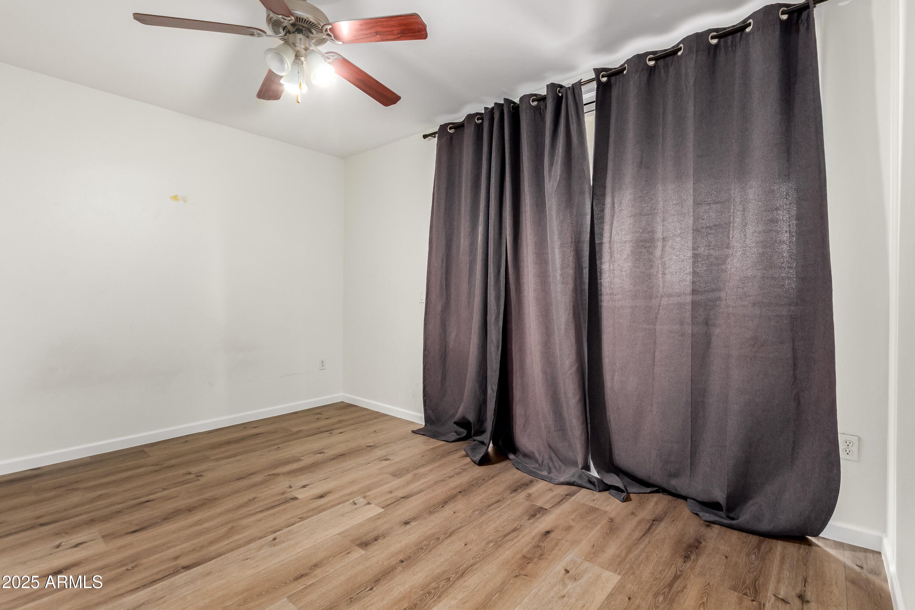2134 East Broadway Road, Unit 2054 Tempe, AZ 85282 - Photo 13 of 17 an empty room with wooden floor and windows