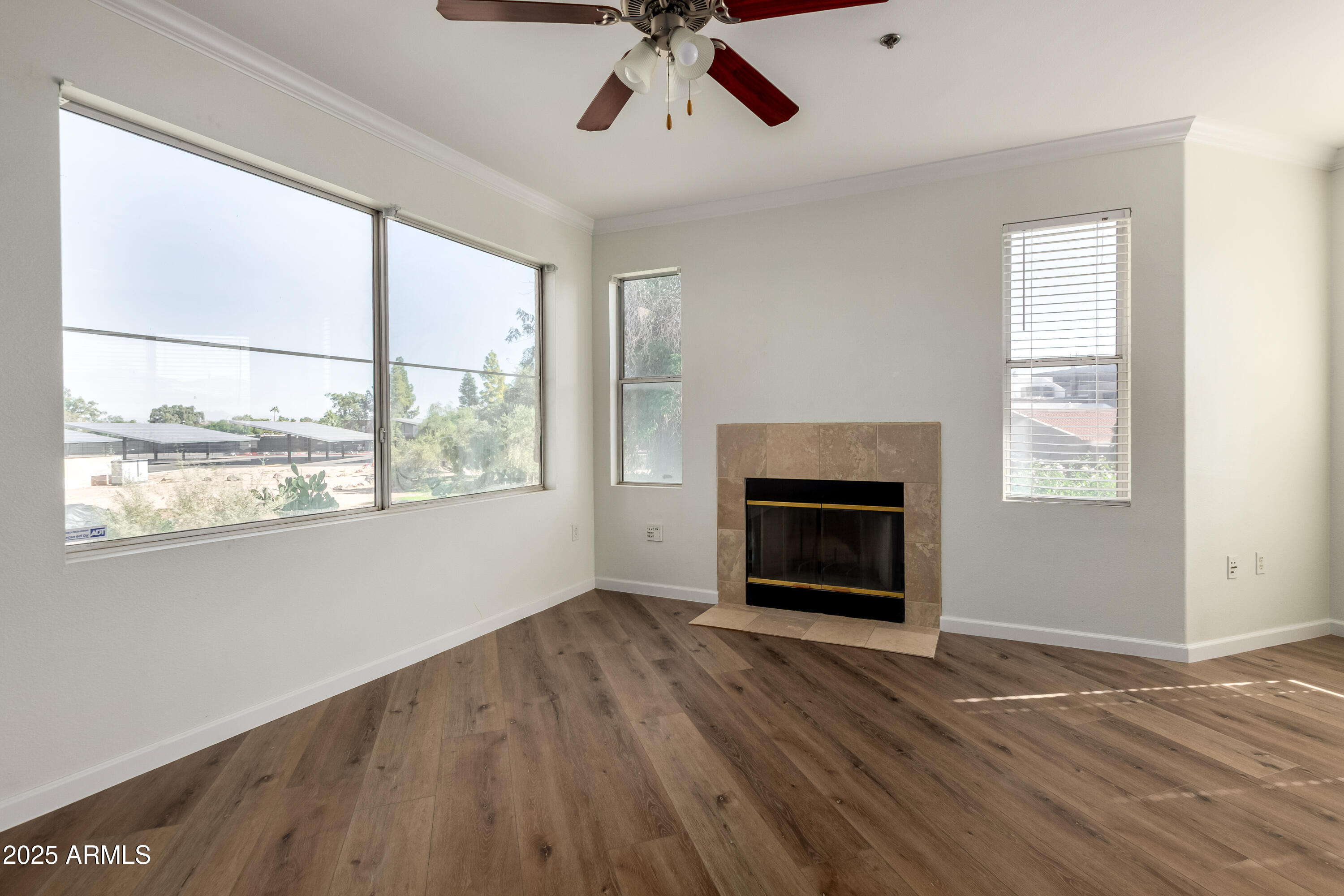 2134 East Broadway Road, Unit 2054 Tempe, AZ 85282 - Photo 2 of 17 a view of an empty room with wooden floor fireplace and a window