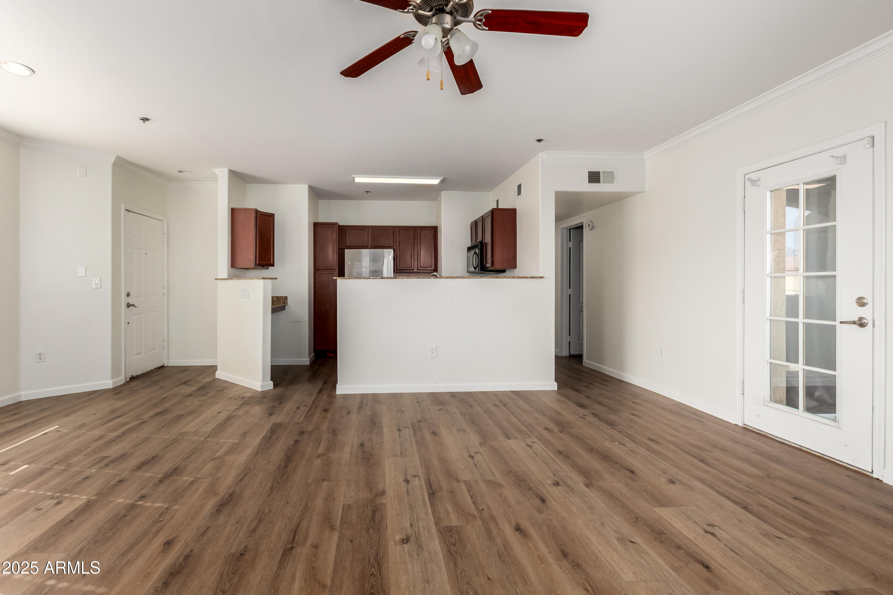 2134 East Broadway Road, Unit 2054 Tempe, AZ 85282 - Photo 4 of 17 a view of a kitchen with a fridge wooden floor and a ceiling fan