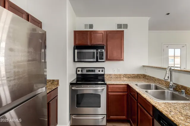 a kitchen with granite countertop a sink stove and microwave
