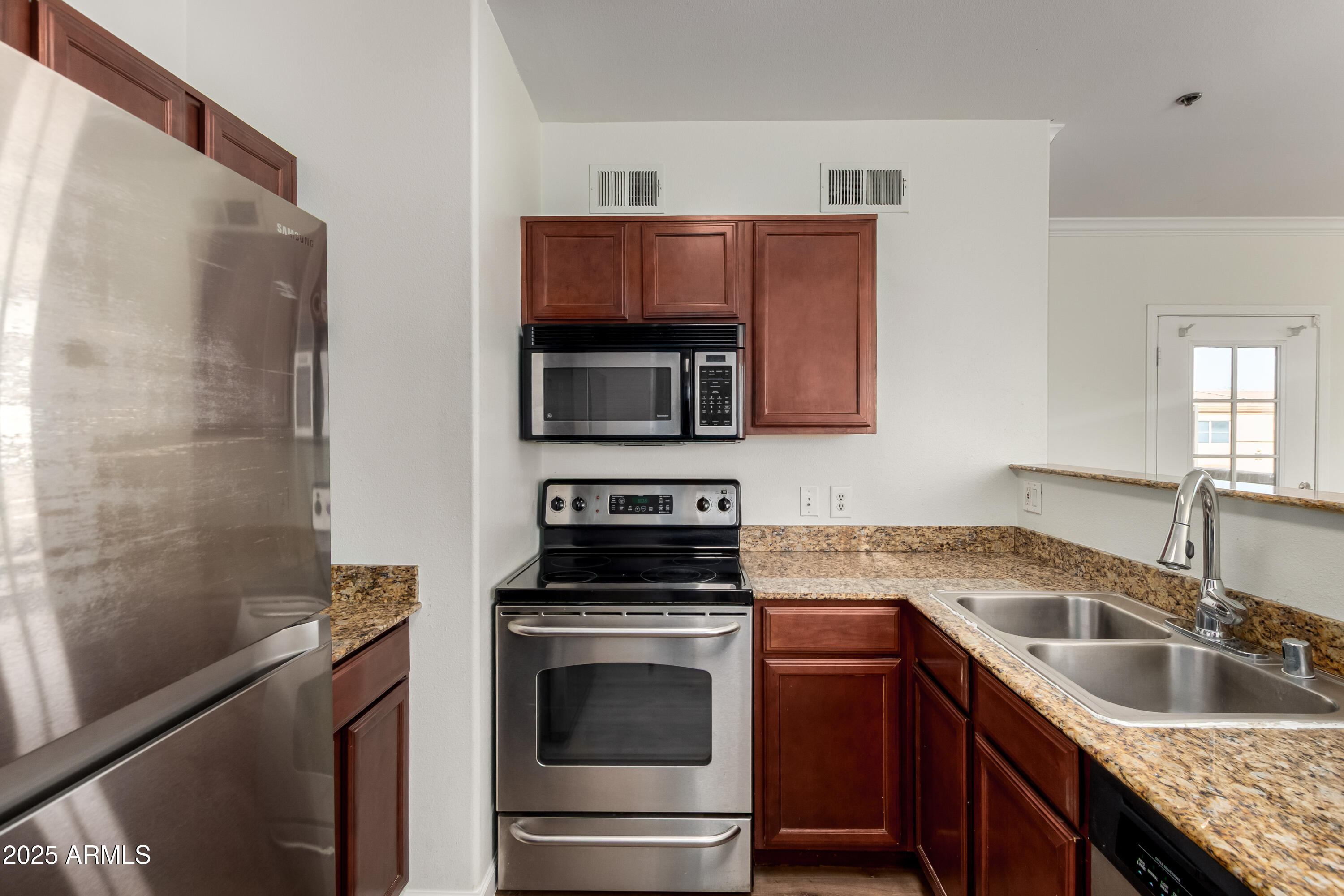 2134 East Broadway Road, Unit 2054 Tempe, AZ 85282 - Photo 5 of 17 a kitchen with granite countertop a sink stove and microwave