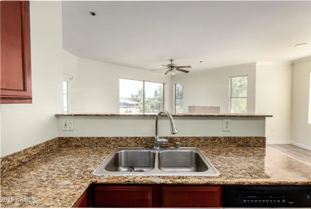 a kitchen with kitchen island granite countertop a sink a counter top space and cabinets
