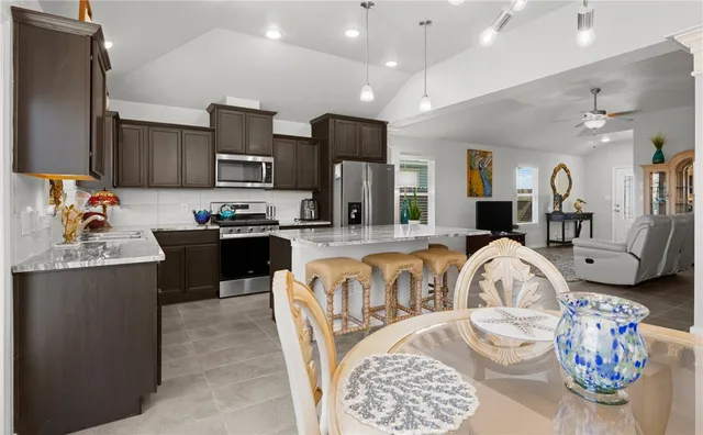 a living room with furniture a flat screen tv and kitchen view