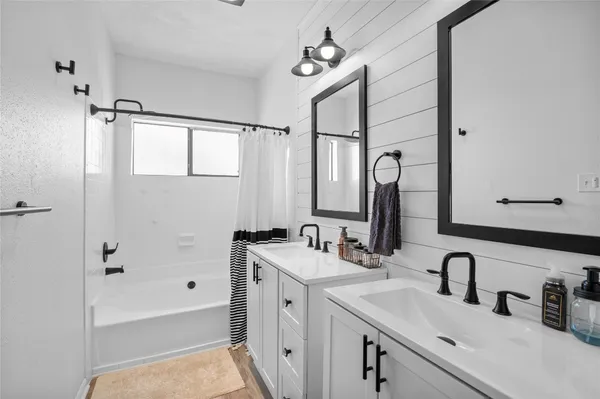 a bathroom with a sink tub vanity and a mirror