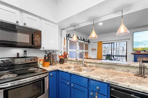 a kitchen with stainless steel appliances granite countertop a sink stove and microwave