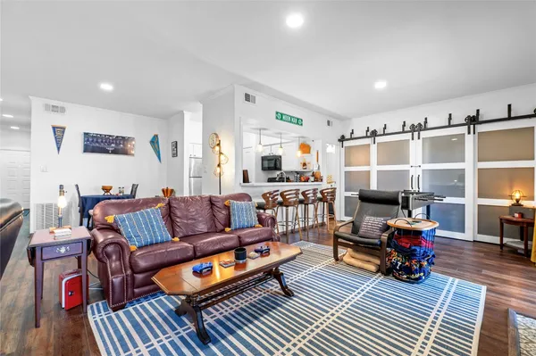 a living room with furniture kitchen view and a flat screen tv