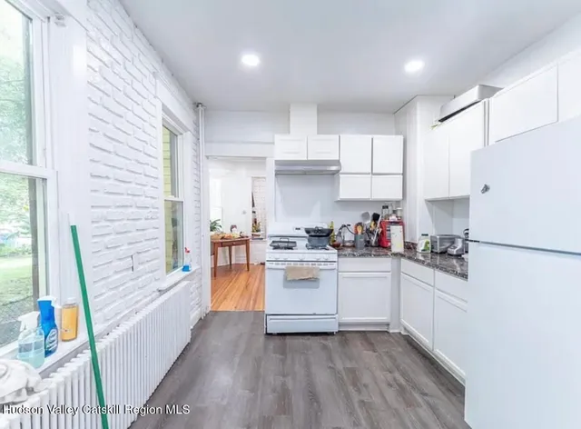 a kitchen with stainless steel appliances granite countertop a refrigerator and a stove top oven