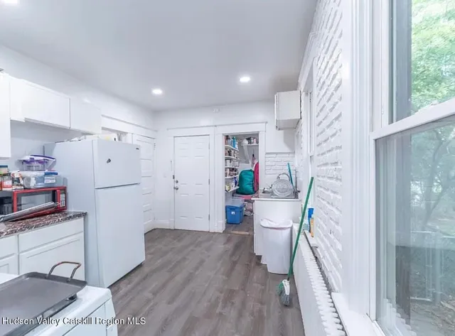 a kitchen with a refrigerator and a wooden floor
