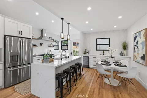a kitchen with stainless steel appliances kitchen island granite countertop a sink refrigerator and cabinets
