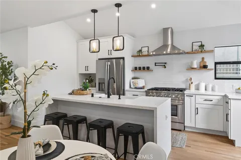 a kitchen with stainless steel appliances granite countertop a stove a sink and a refrigerator