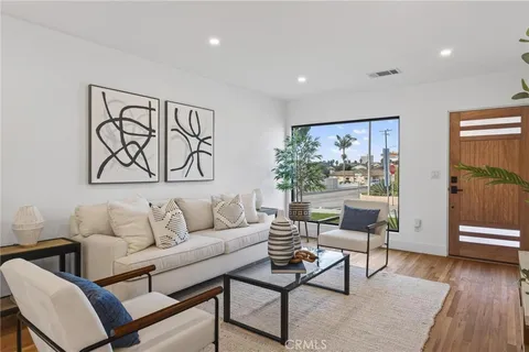 a living room with furniture and wooden floor