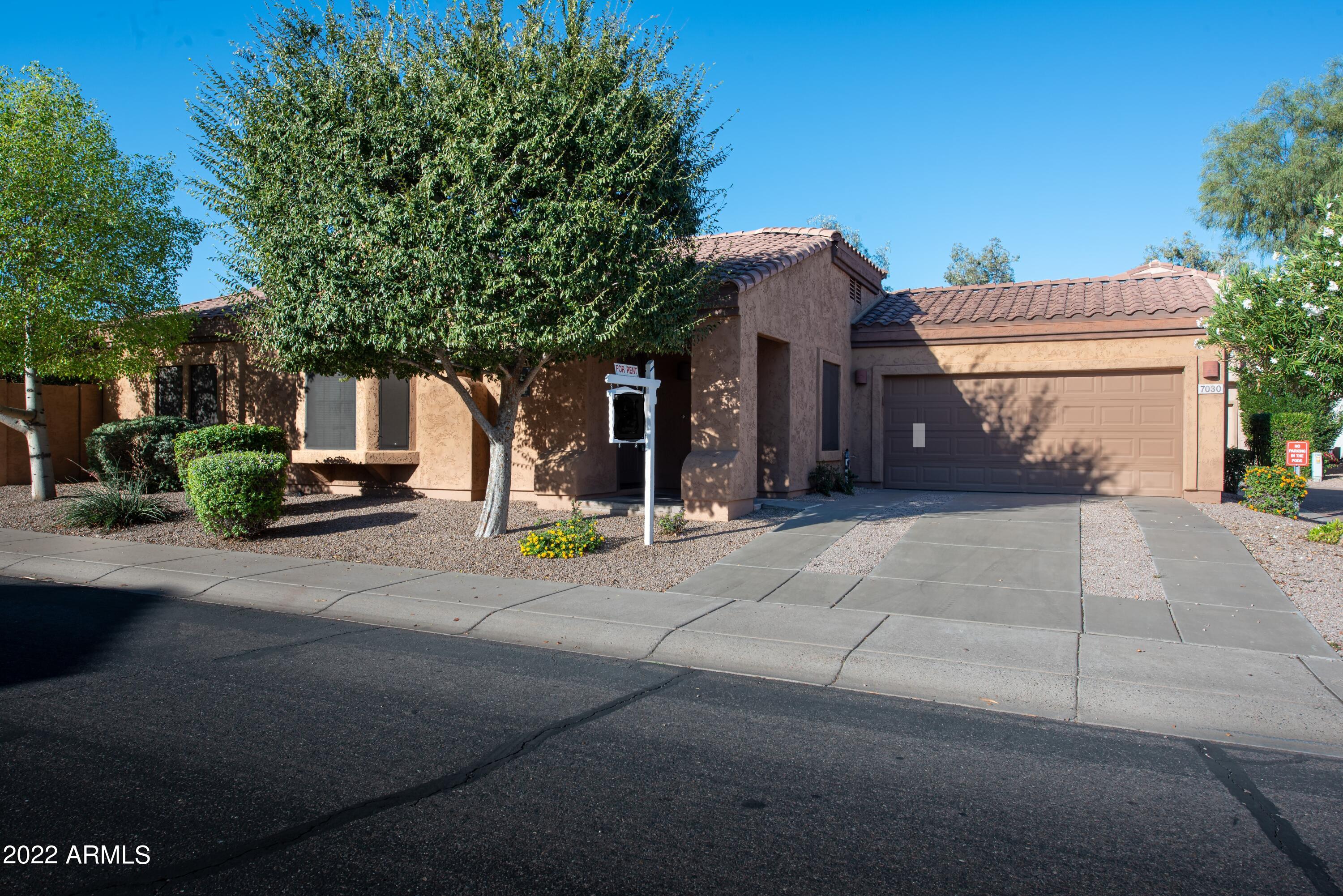 7030 South 30th Street Phoenix, AZ 85042 - Photo 1 of 18 a front view of a house with a garage
