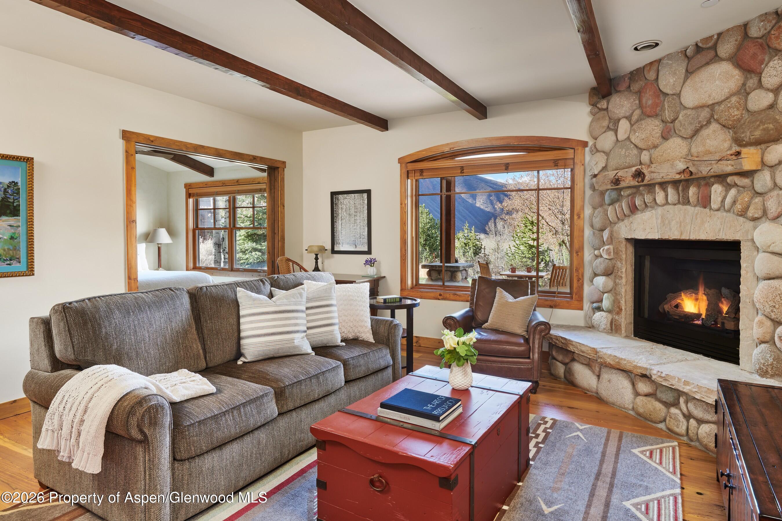 a living room with furniture fireplace and a large window