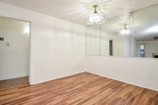 a view of a room with wooden floor and chandelier