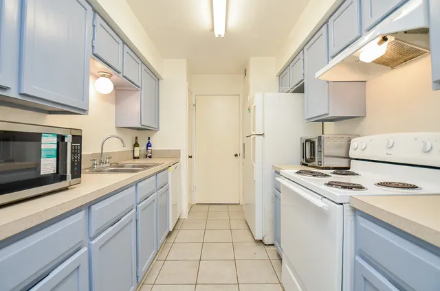 a kitchen with stainless steel appliances granite countertop a stove a sink and a microwave