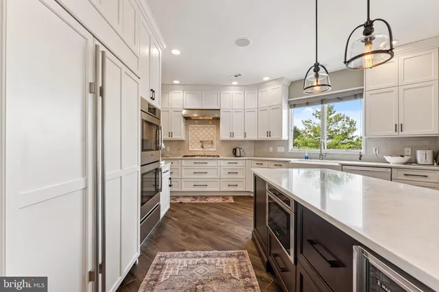 a kitchen with kitchen island granite countertop a sink appliances cabinets and a counter top space