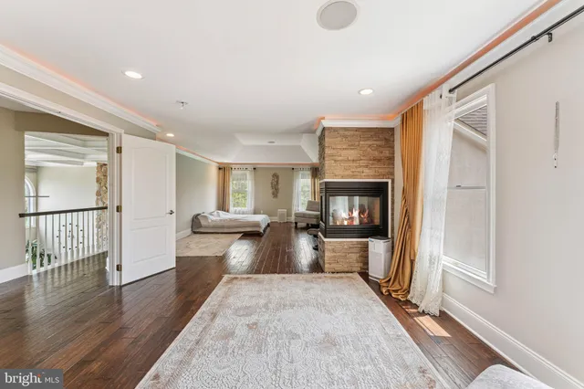 a view of a living room with a fireplace and wooden floor