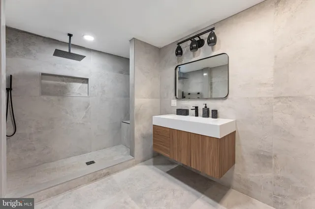 a bathroom with a sink a mirror and a shower