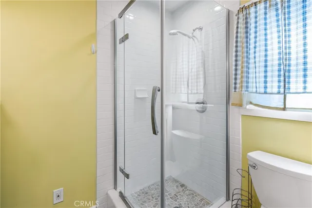 a bathroom with a granite countertop shower and a toilet