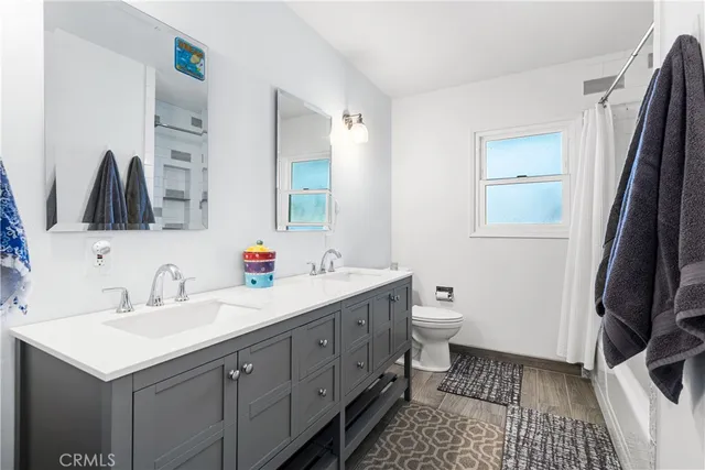 a bathroom with a sink a toilet and a mirror