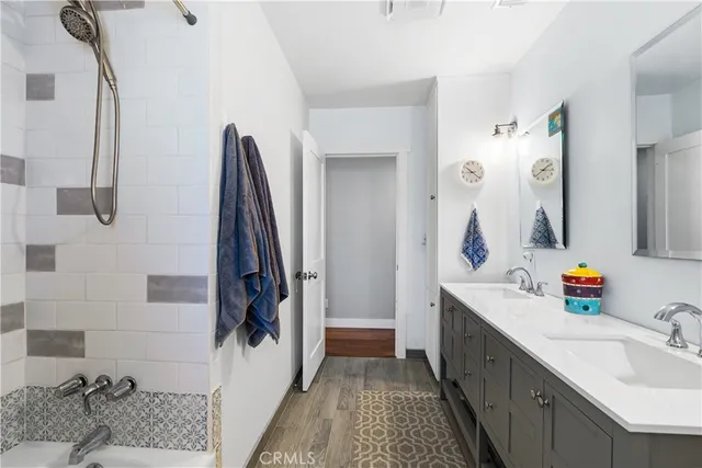 a bathroom with a double vanity sink a mirror and shower