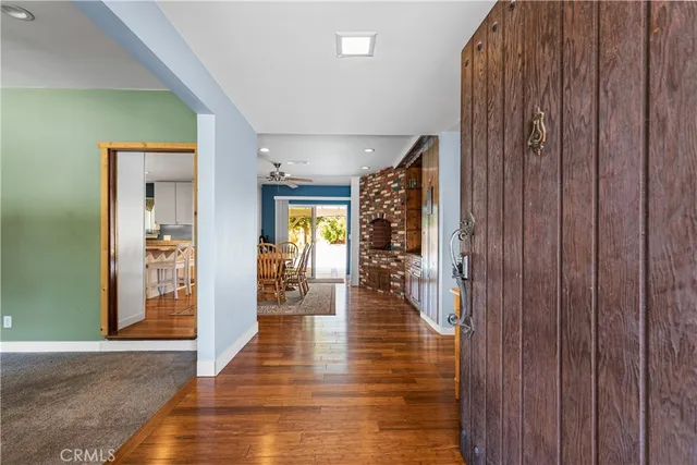 a hallway with wooden floor table and chairs