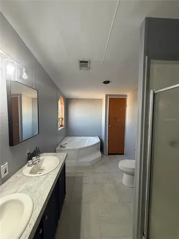 a spacious bathroom with a granite countertop sink and a mirror