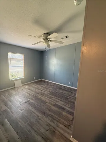 a view of empty room with window and wooden floor