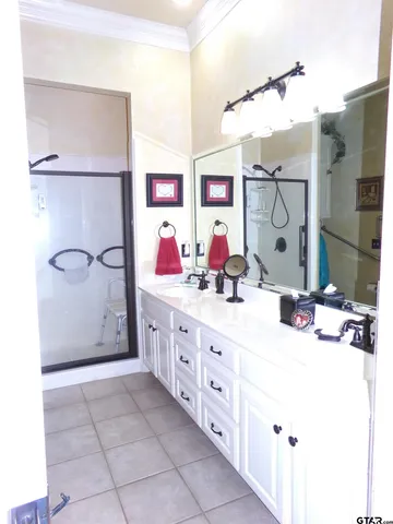 a bathroom with a double vanity sink mirror and shower